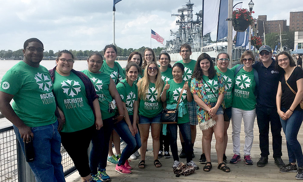 All of the members of the Rochester Youth Year Fellows are pictured in matching green shirts on a dock in front of a ship in Buffalo, NY