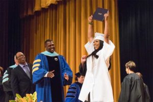 female student raising her diploma during East High graduation