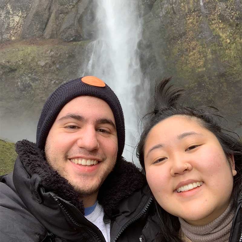 couple posting a selfie in front of water fall