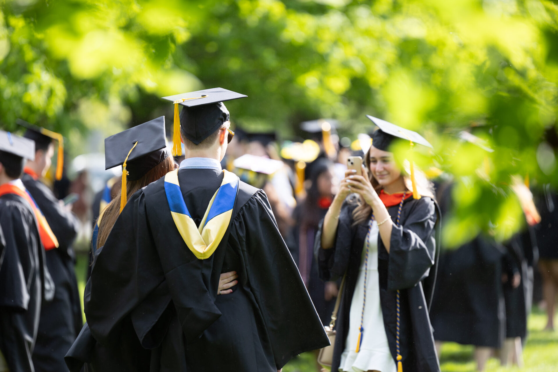 student taking a photo of fellow student after gradudation