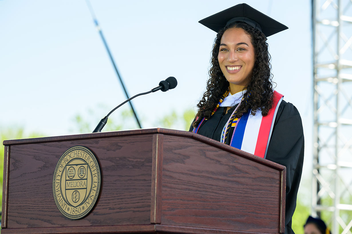 Kate Hidalgo in cap and gown at podium
