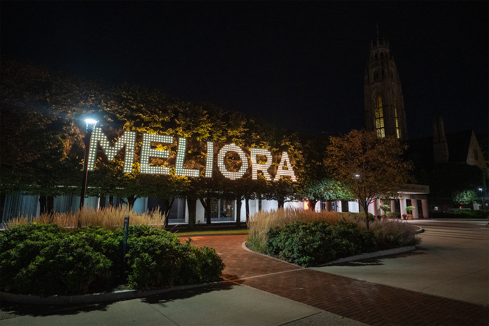 Meliora letters on building at dark