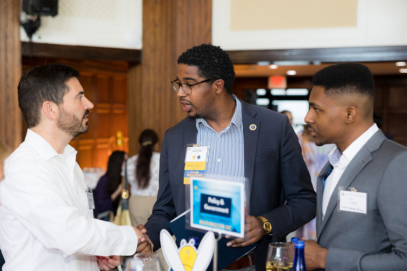 Jamal Holtz shaking hands with another man