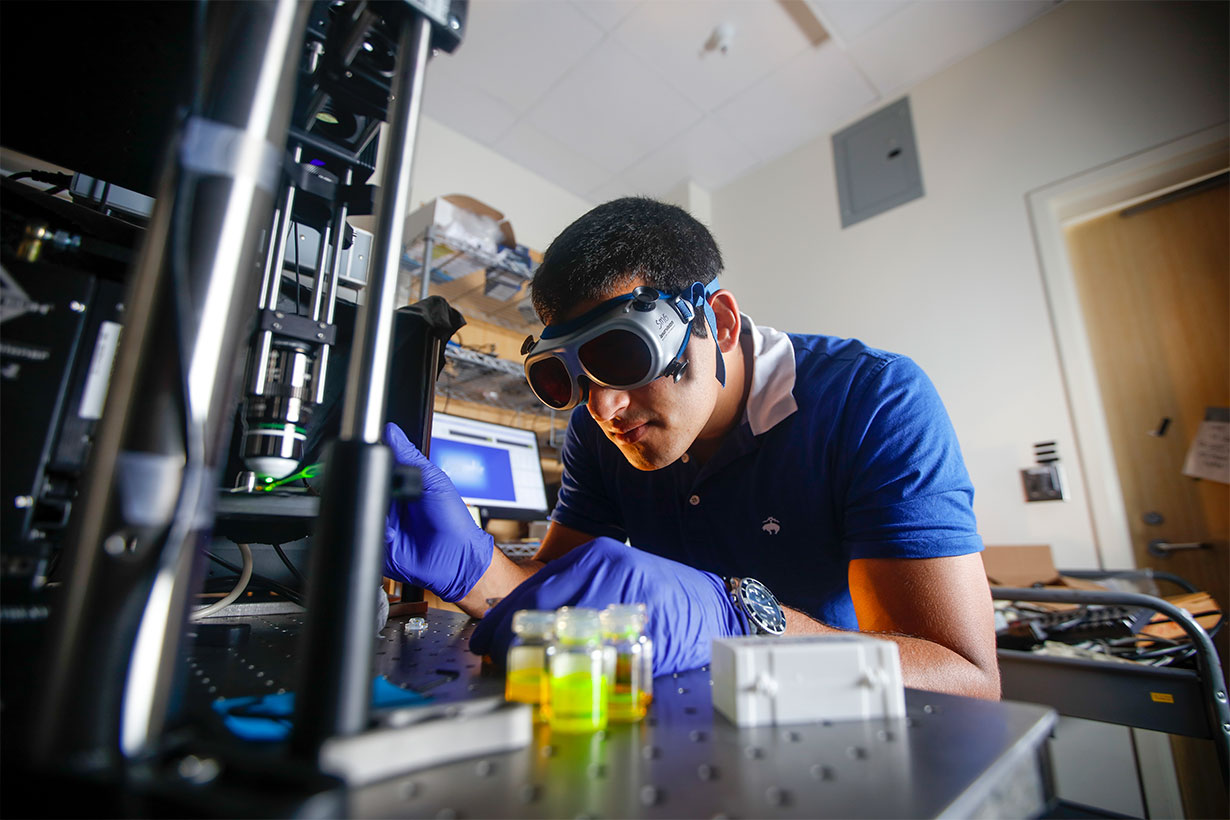 student in lab wearing protective glasses