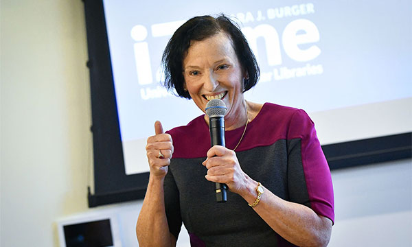 Barbara J. Burger ’83 standing with microphone in front of crowd