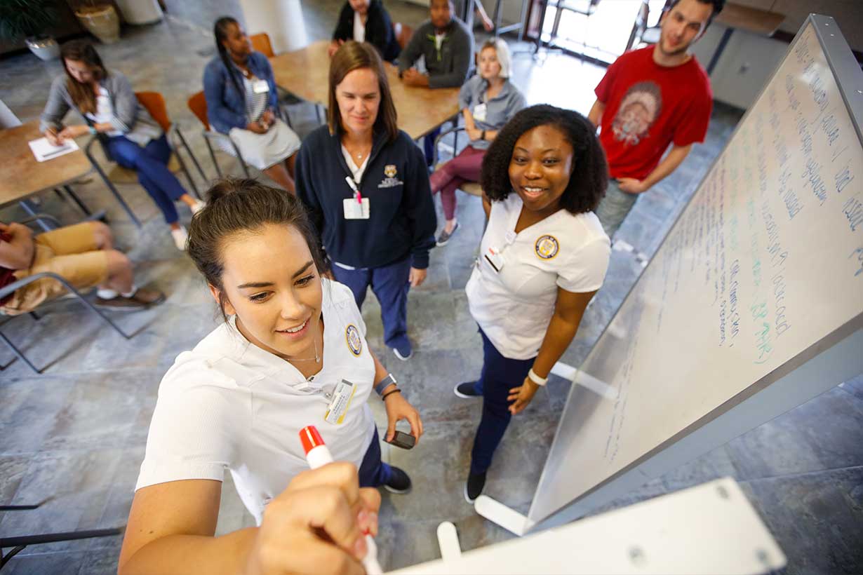 Medical works writing on a whiteboard