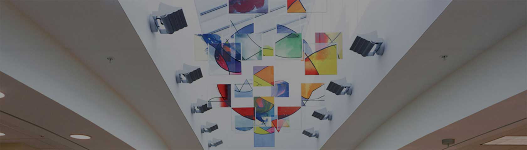 a white ceiling with several colored hanging shapes