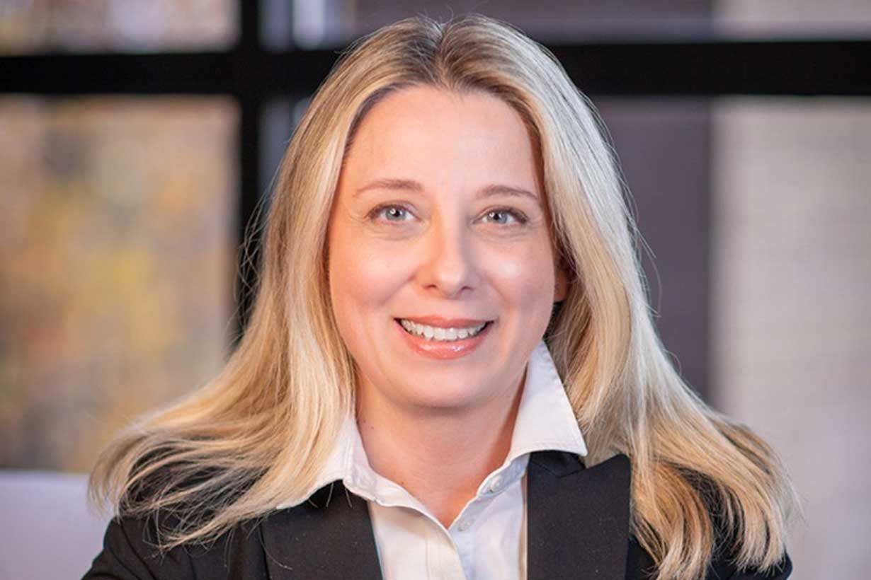 Melissa Head, seen smiling, wearing a blazer and blouse