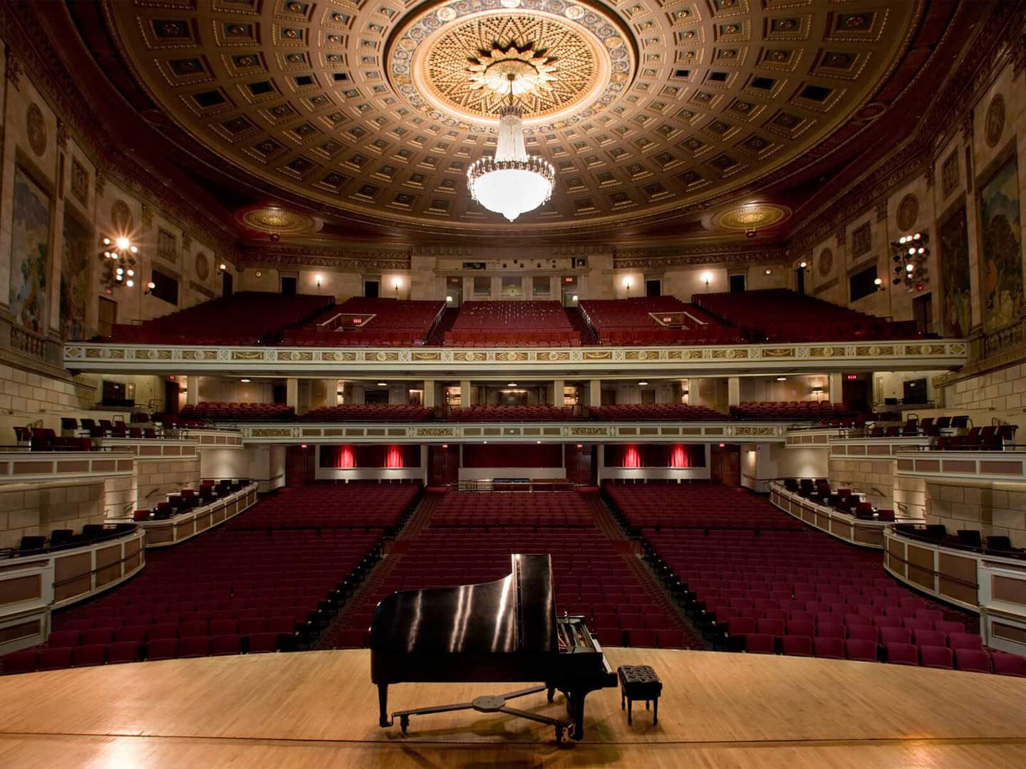 grand piano on stage at Kodak Hall, seen from perspective of the stage looking out into the empty audience seats
