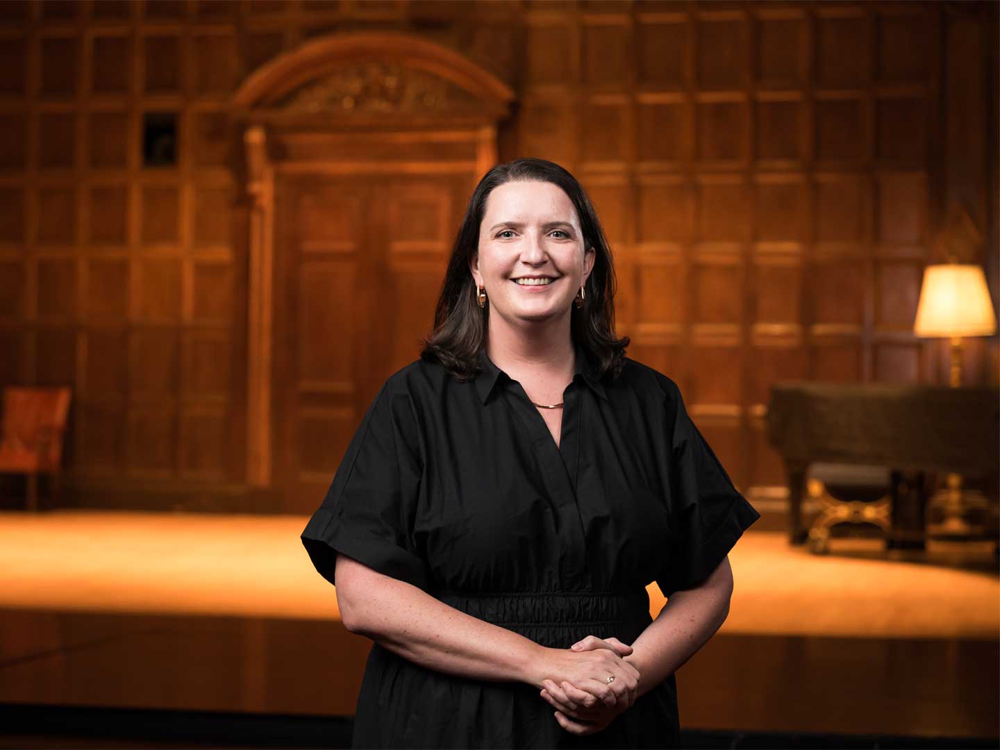 Kate Sheeran, seen smiling, standing in front of the stage at Eastman Theater