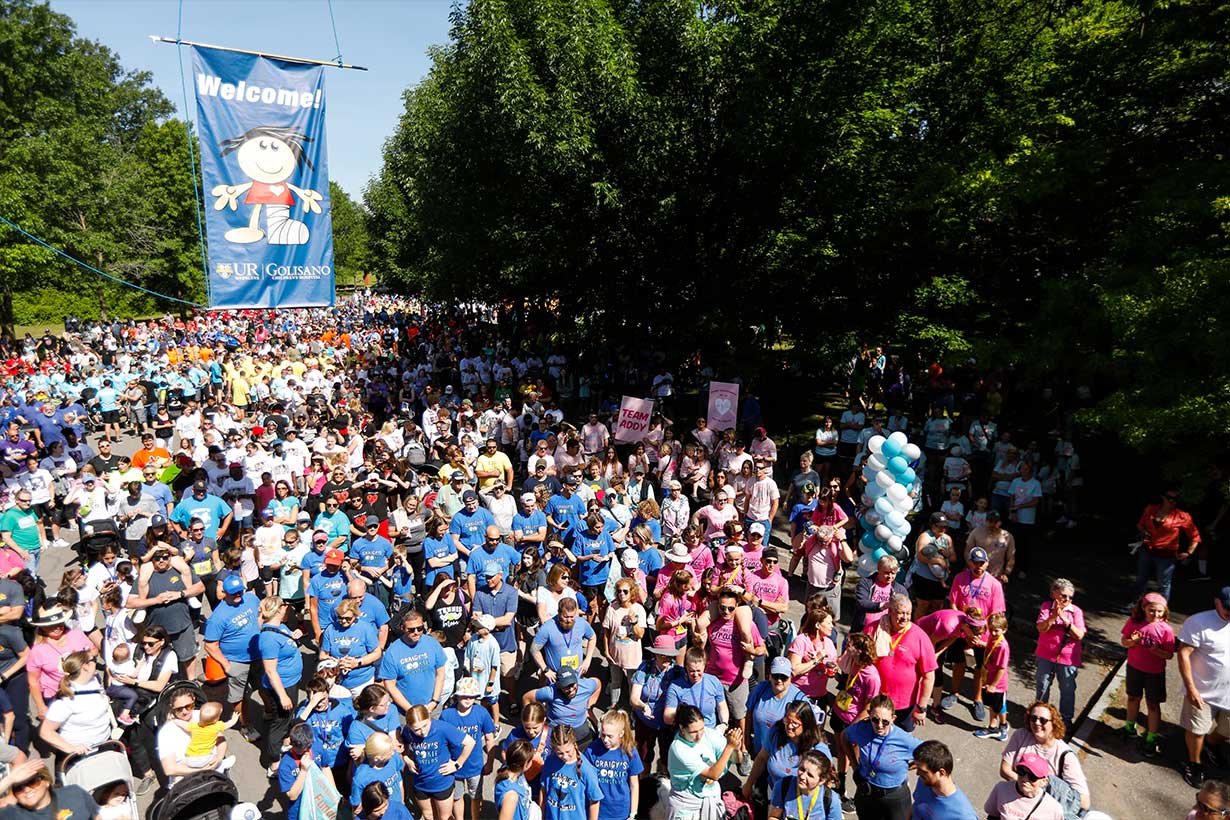 A crowd of people where blue and pink shirts on a street