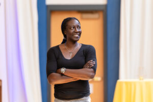 Ladi Ya standing with her arms crossed.