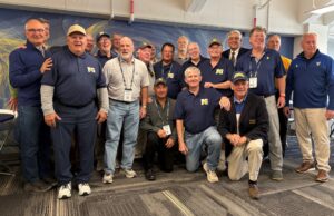 Following the Yellowjacket football team’s homecoming victory over St. John Fisher during Meliora Weekend 2025, a number of URochester alumni who played for Coach Pat Stark (1969–1983) gathered at a “Tribute To The Coach” in the Stark Meeting Room at Fauver Stadium. Some are pictured here*.