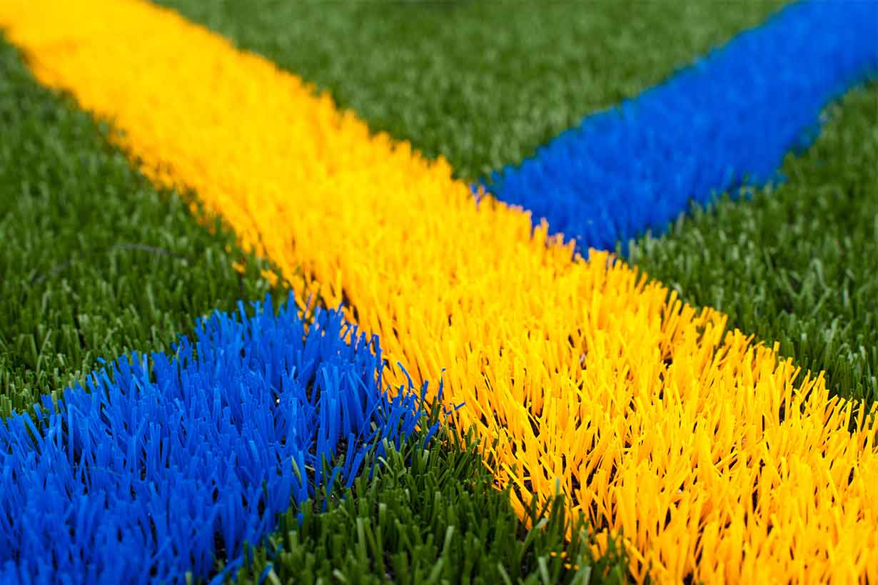 green grass with UR colors yellow and blue lines criss crossing
